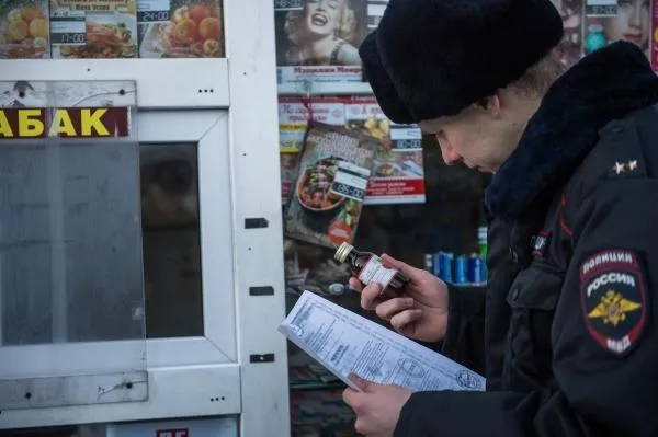 Сотрудник правоохранительных органов проверяет документы на спиртосодержащие средства в одном из киосков Омска. Алексей Мальгавко